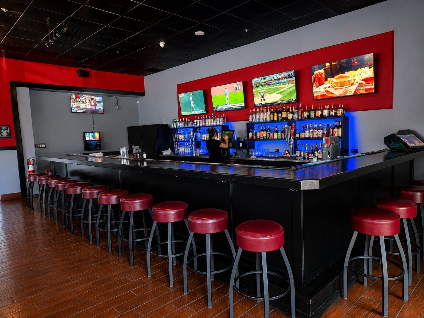 The bar and its screens, stools lined up
