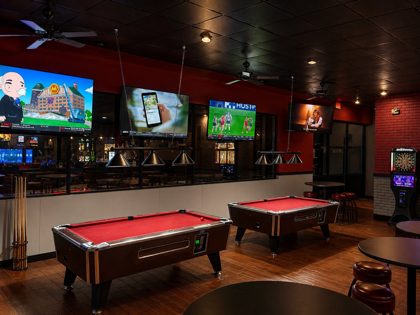 Two red-felt pool tables under the screens